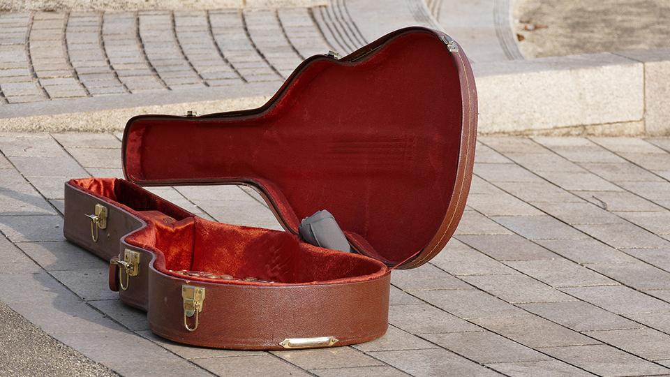 A picture of a busker's guitar lying on the ground