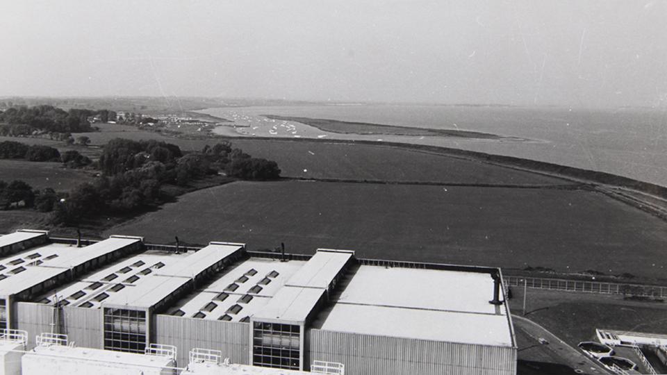 Black and white photo of fields by the coast taken from top of an industrial building