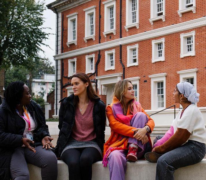 Four students sitting outside Goldsmiths' main building