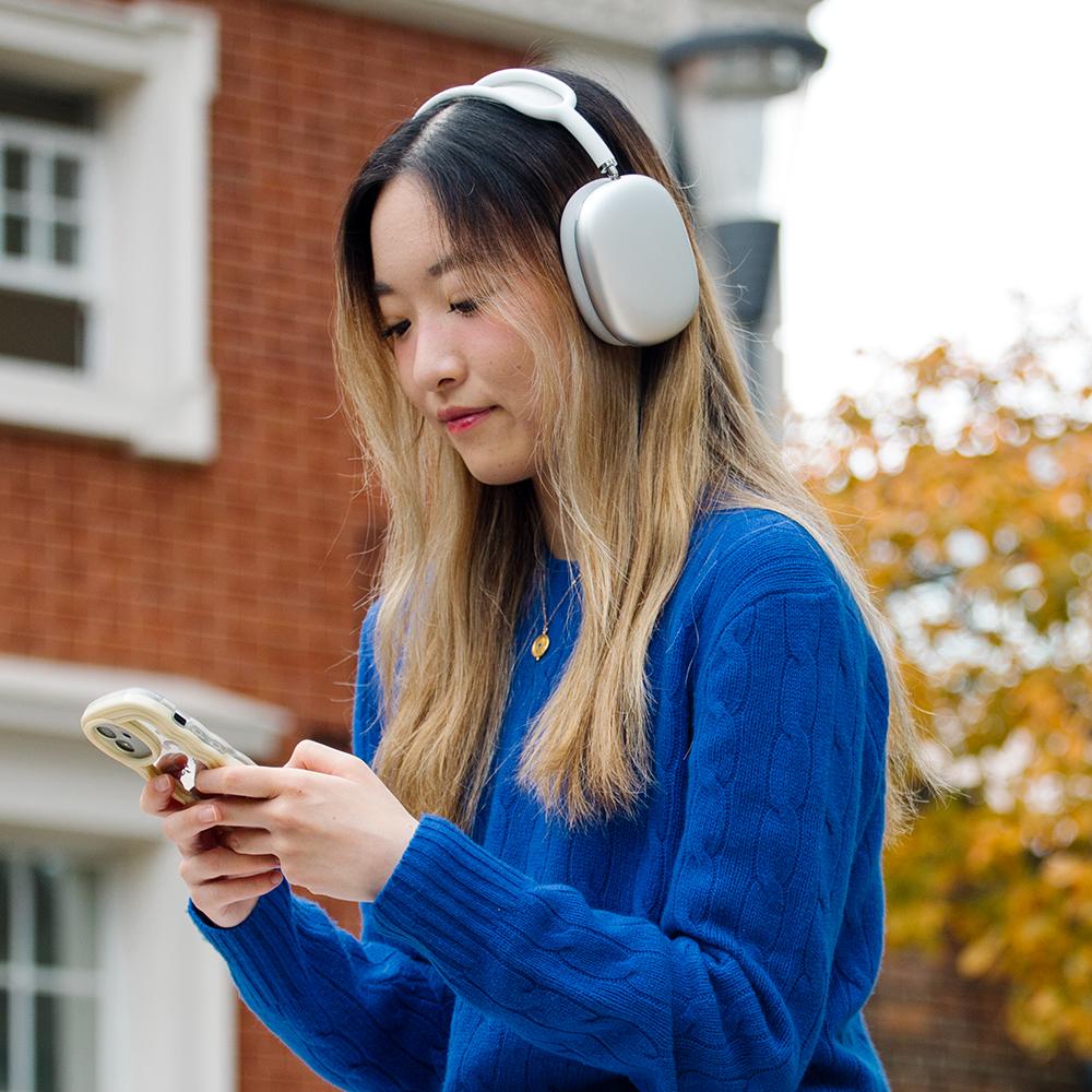 Girl looking at phone while wearing headphones