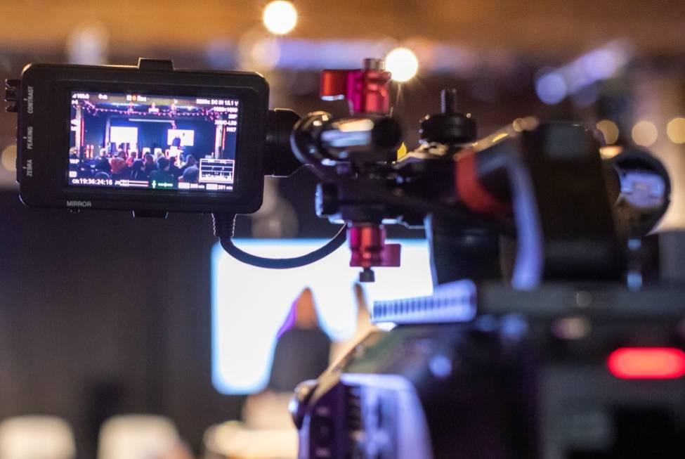 A picture of a camera viewfinder focusing on a conference stage
