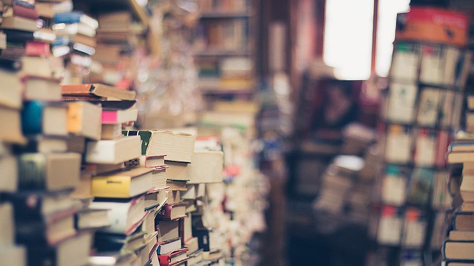 A picture of books stacked high in a shop