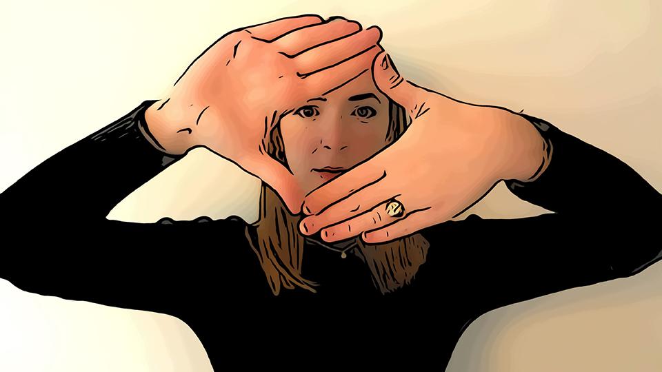 Image shows a woman with hands positioned in front of her face to form a diamond shape