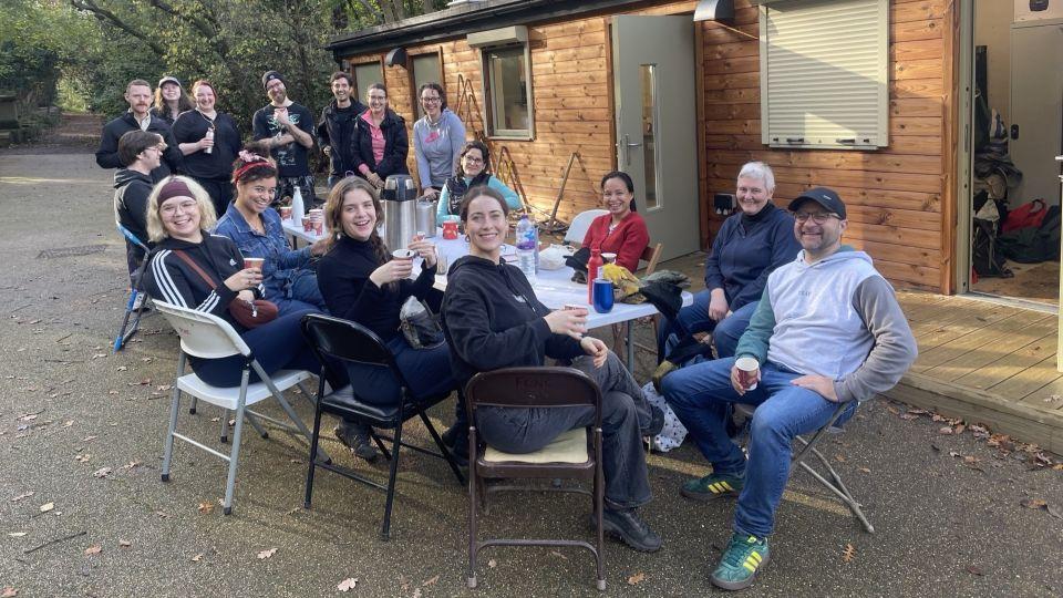 Staff sat around a table outside a wooden cabin