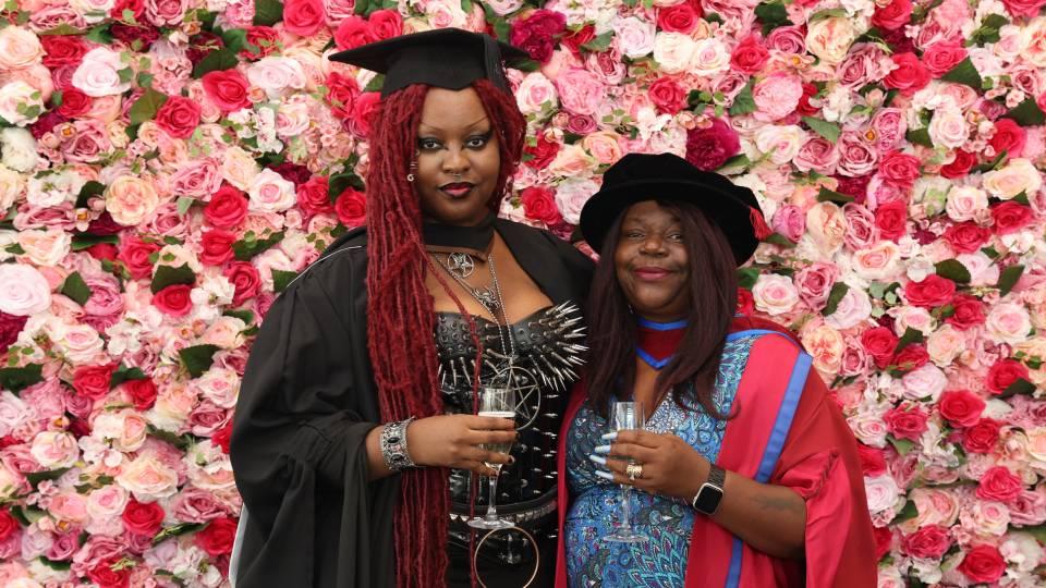 Two females, one undergraduate - left, and capped academic - right. 