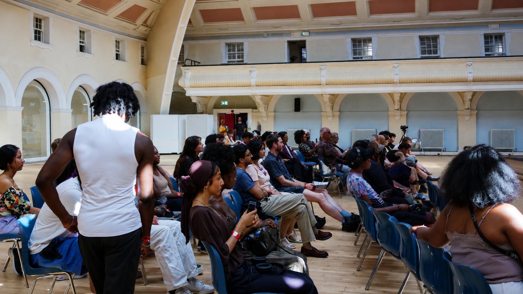 Audience members seated and standing the Great Hall, Goldsmiths