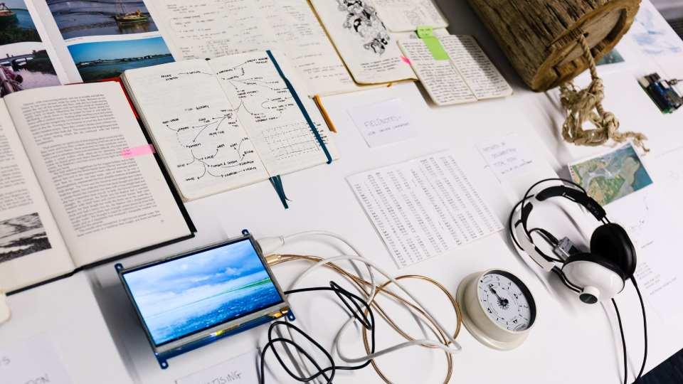 Sketchbooks, prototypes, and research materials on display, highlighting the diverse creative‑computing practices across the department.