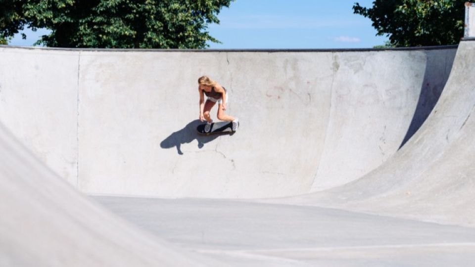 Dr Esther Sayers skateboarding in a grey concrete bowl 