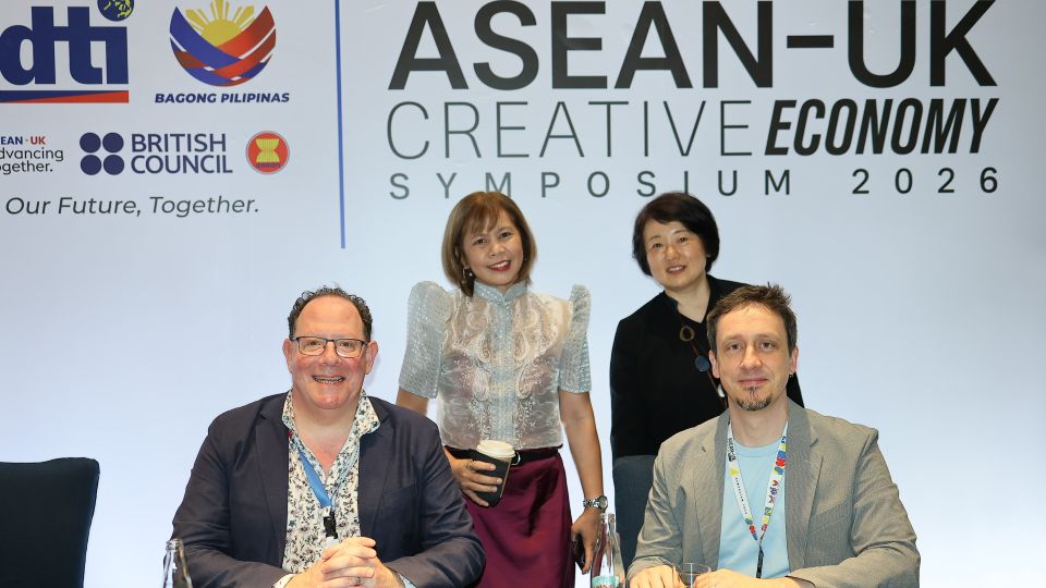 Professor Jonathan Freeman and André Piza with two other people in front of a background that says ASEAN-UK Creative Economy Symposium 2026.