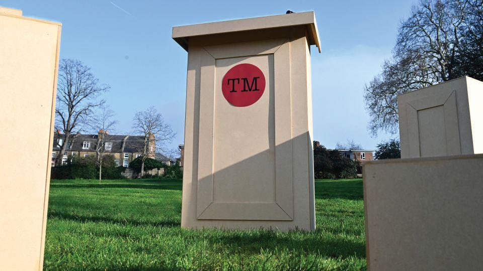 A wooden judge's podium with the red Taskmaster logo on the College Green. 