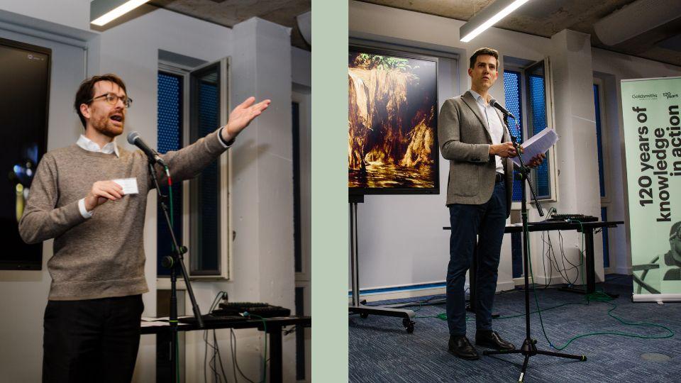Two males speak into mic stand - one left gesturing with his left hand, the other right, in smart jacket
