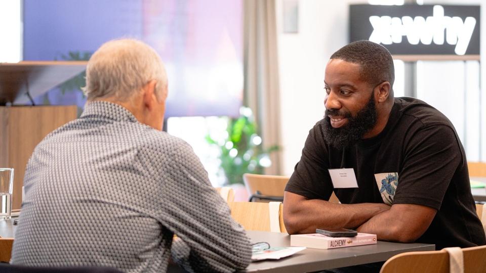 Two participants in discussion at the Scale Creative Leaders event.