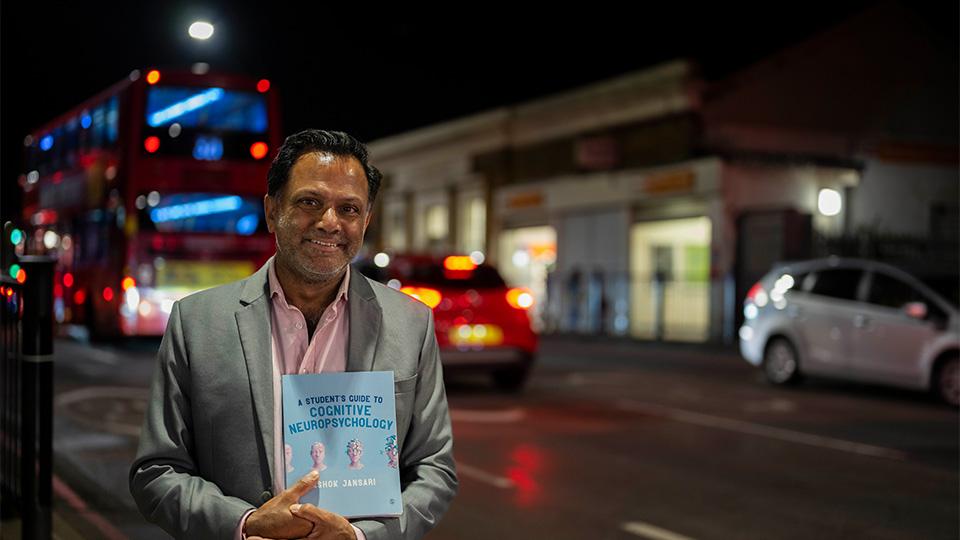 Ashok holding his book, A Student’s Guide to Cognitive Neuropsychology.