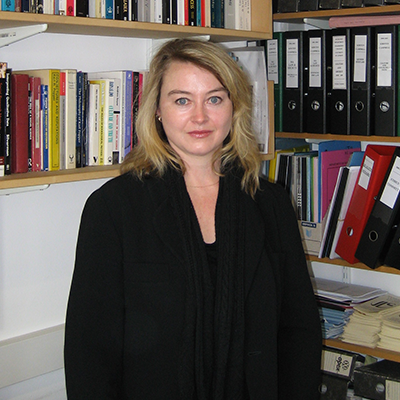 Image of Kirsten Campbell standing in front of bookshelves