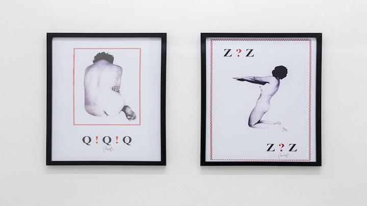 Two framed prints, the same size, hung next to one another. Both with black and white photos of naked women and typography.
