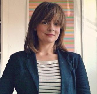 A photo of Alice wearing a blazer and striped top