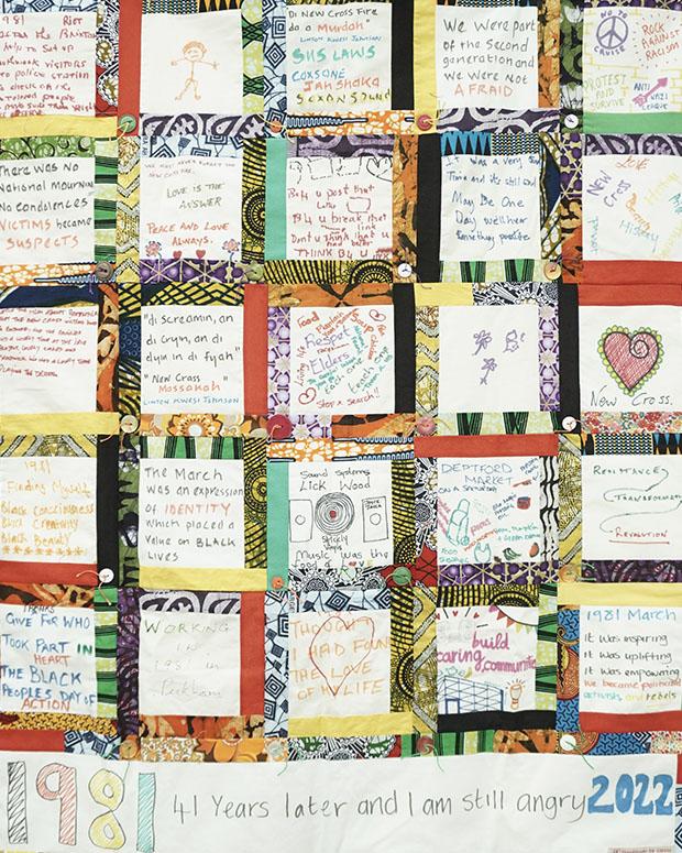 Image of a tapestry that reads '1981 41 years later and I am still angry 2022' across the bottom. Above, rows of square hand-drawn notes are surrounded by colourful textiles