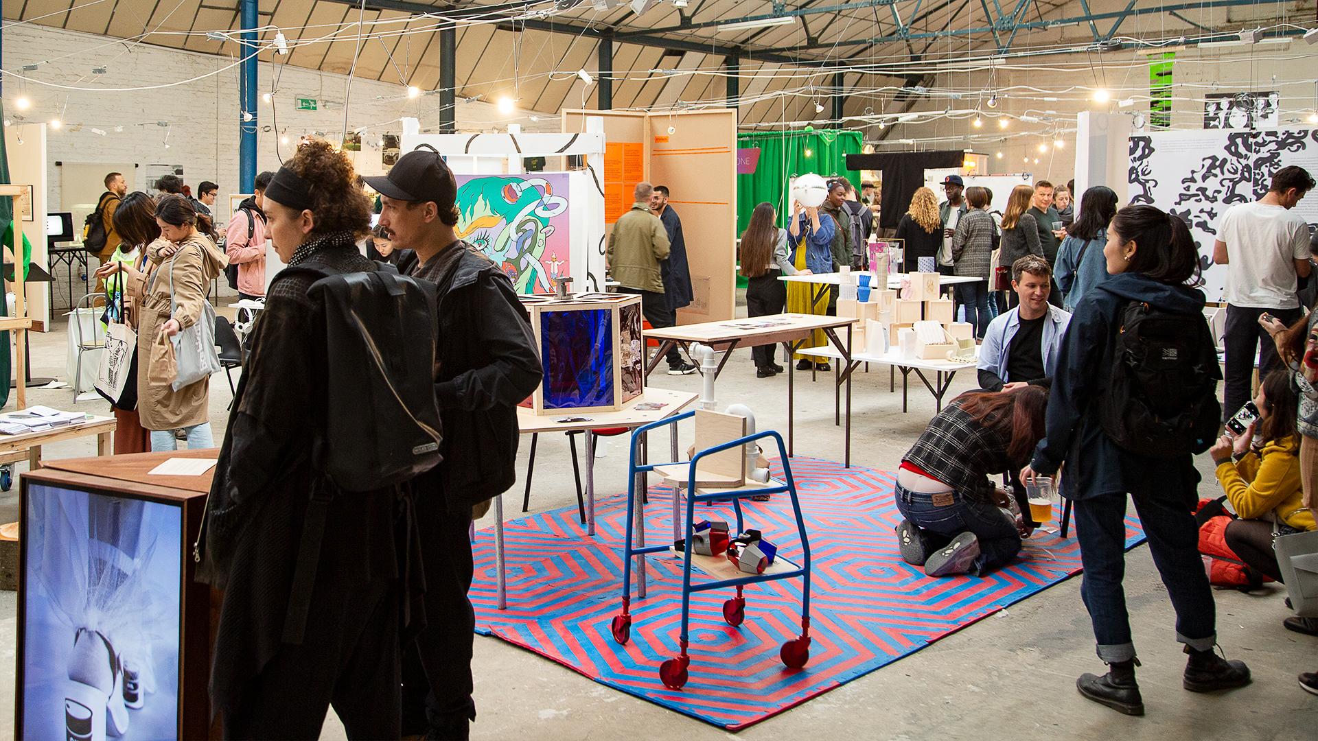 An exhibition space is filled with colourful work by BA Design students