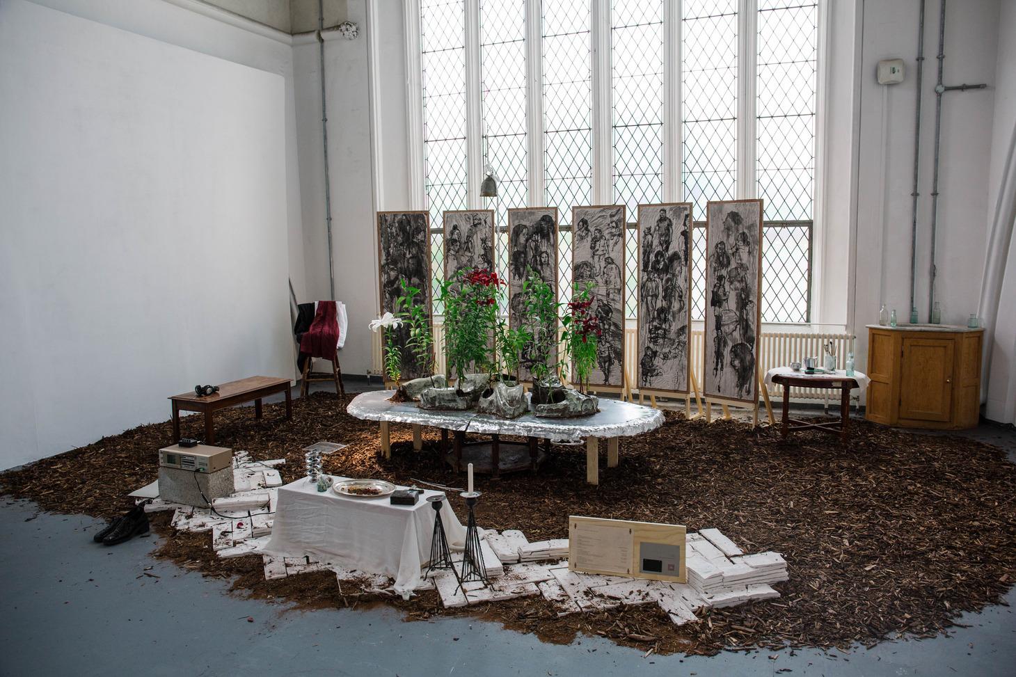 A well-furnished room with a table, several chairs, and a colourful bouquet of flowers as a centrepiece