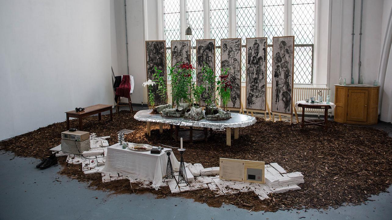 A well-furnished room with a table, several chairs, and a colourful bouquet of flowers as a centrepiece