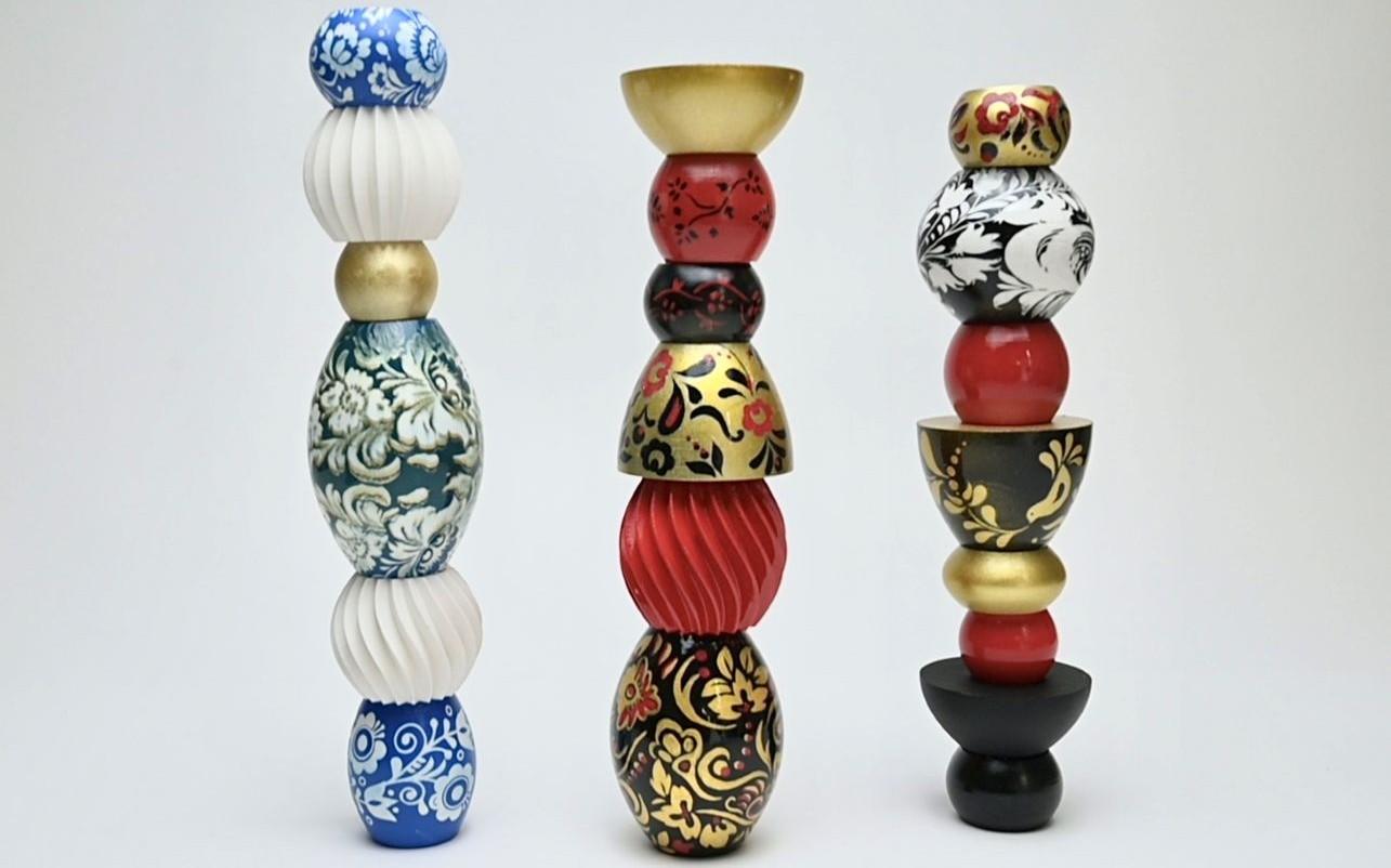 Three columns of customised beads. The first column has blue and white beads, the second and third column have black, red and gold beads with folk art designs.  