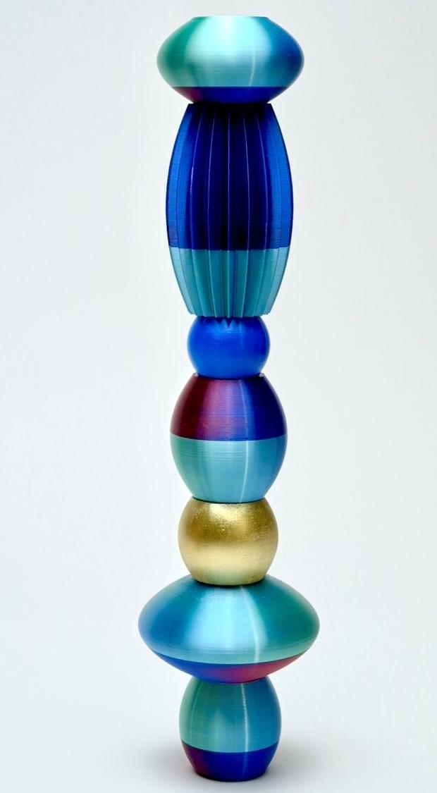 A stack of shiny beads in different shapes in blue, purple and gold colours
