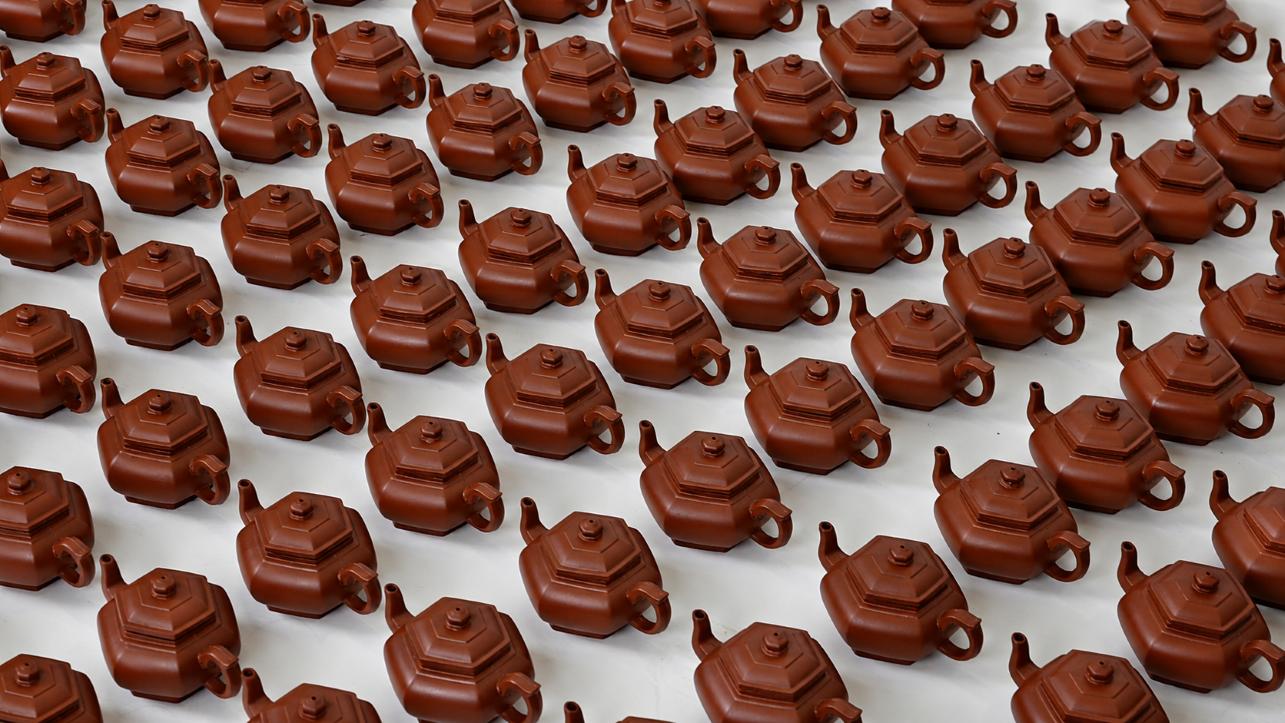 Identical brown teapots aligned in rows 