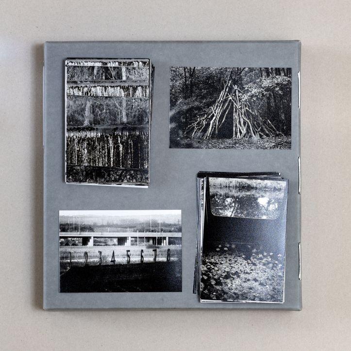 Four black and white photographs on a grey page. One shows a den made of sticks. One shows a road and some numbers from 1 to 8. 