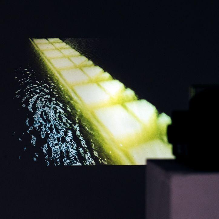 A slide projector projecting an image of a yellow object and water