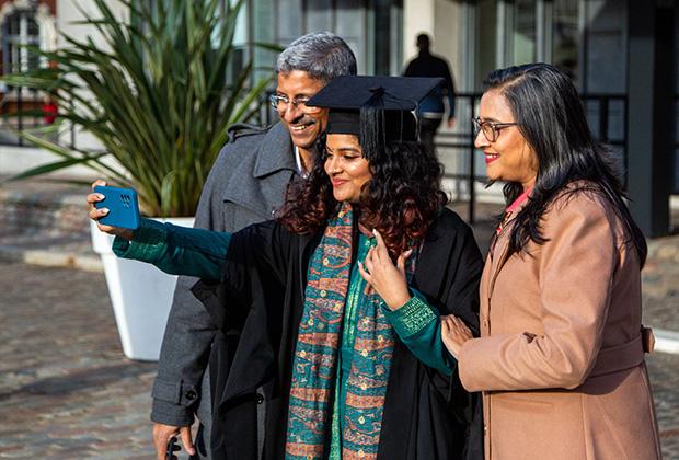 A graduate takes her photo with her family