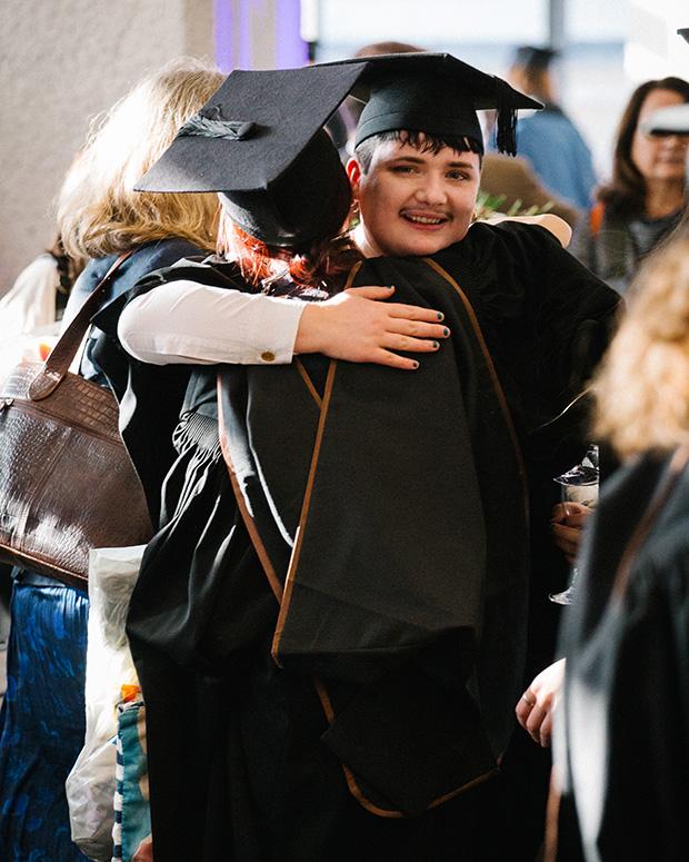 Two graduates hugging