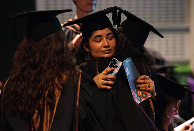 Graduates hugging before the ceremony