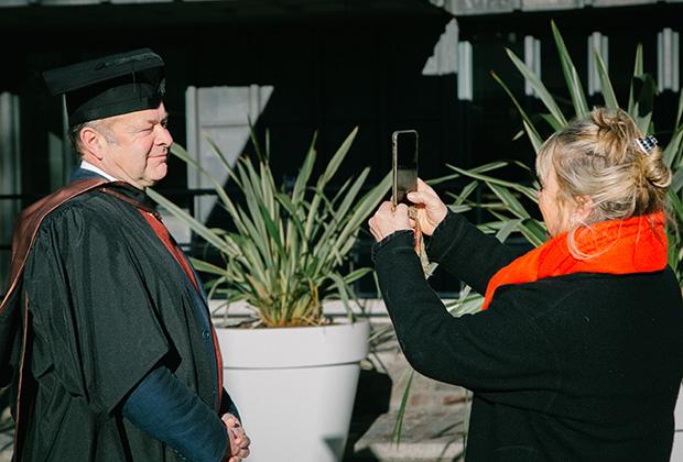 Mature student having his photo taken on a phone