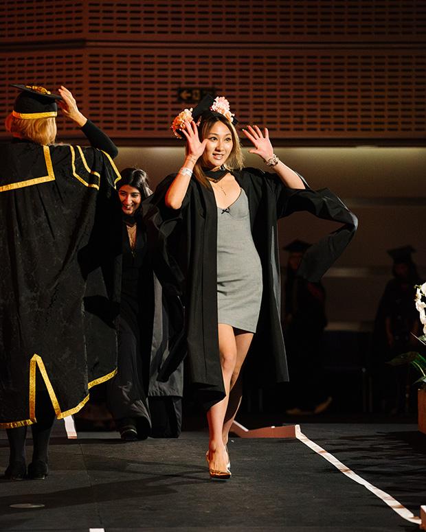 Graduate waves to the audience with both hands