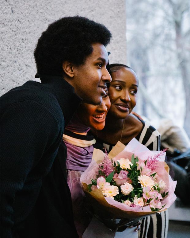 A group hugs and poses for a photo at a graduation ceremony.
