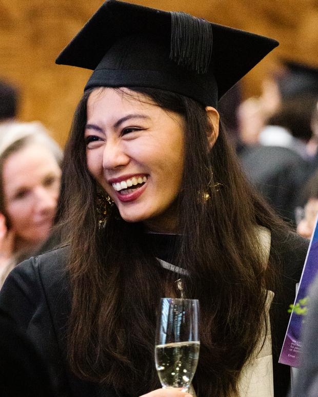 Female graduate smiling wearing robe and hat