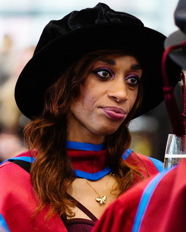 Female graduate wearing red robe and black cap