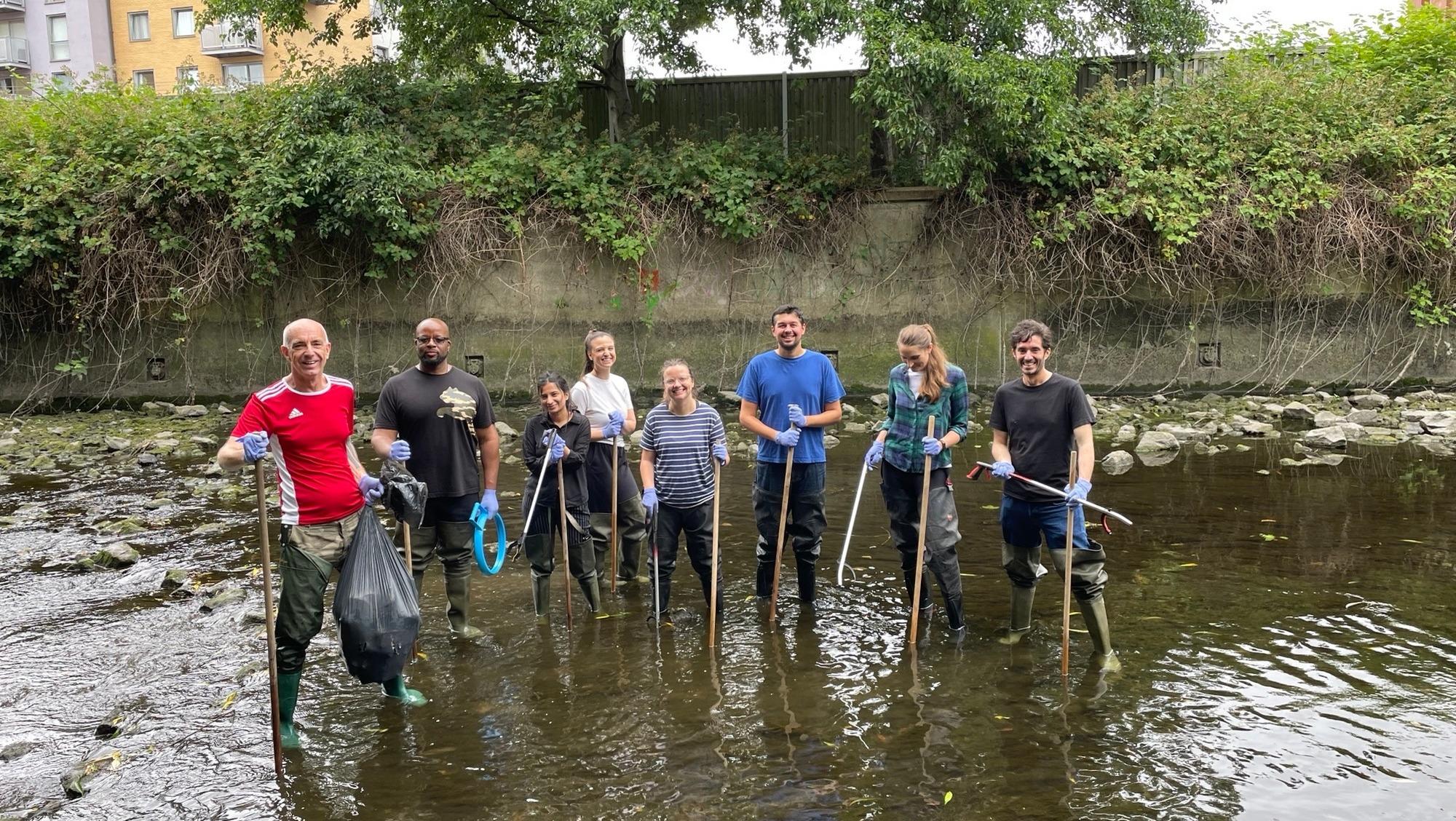 A group of staff stood in a river
