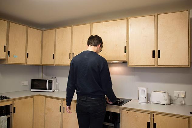 A male student standing in a student kitchen