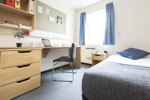 Inside a student halls bedroom with a bed and desk