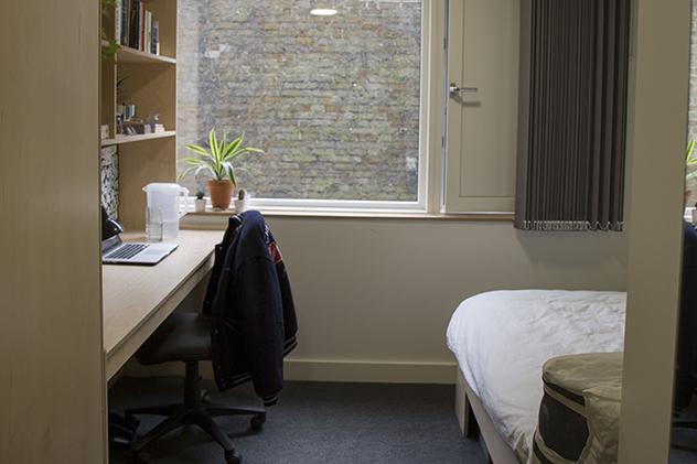 A student room in halls with a bed and desk
