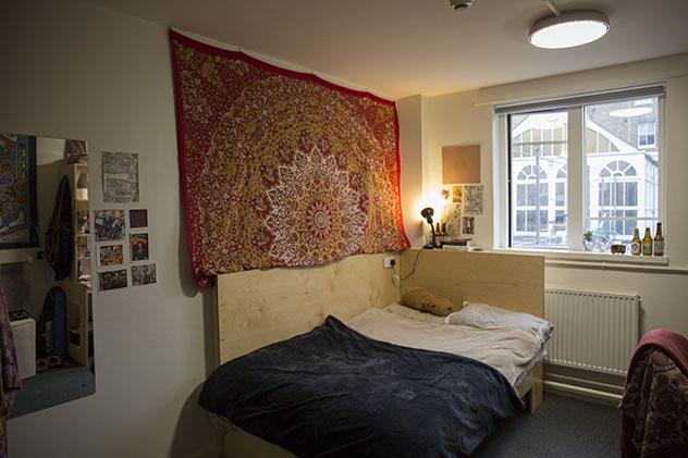 A student bedroom with a wall hanging in halls