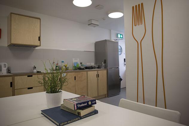 A student kitchen with large knife and fork mural on wall
