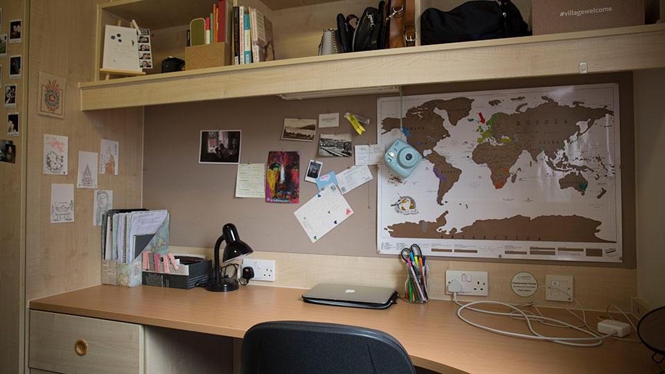 A desk with noticeboard in a student room