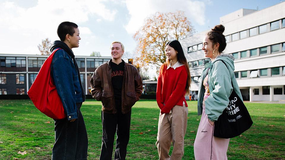 Four students chatting on the College Green