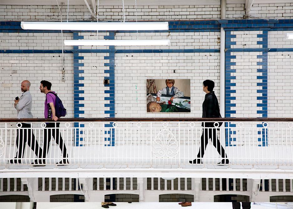 Students walking past a painting on the balcony of Laurie Grove Baths.