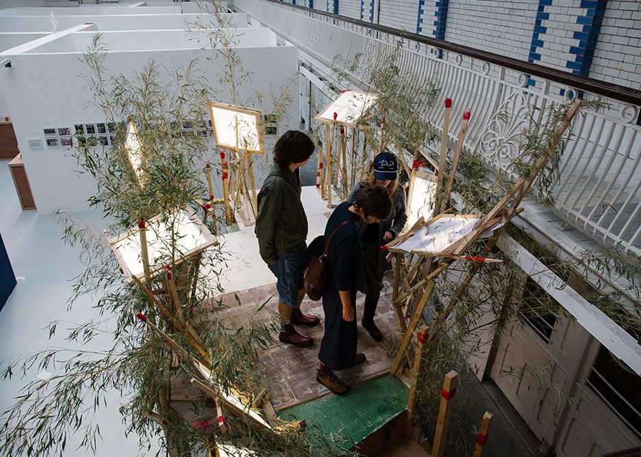 Students standing on a wooden platform that forms part of an installation.