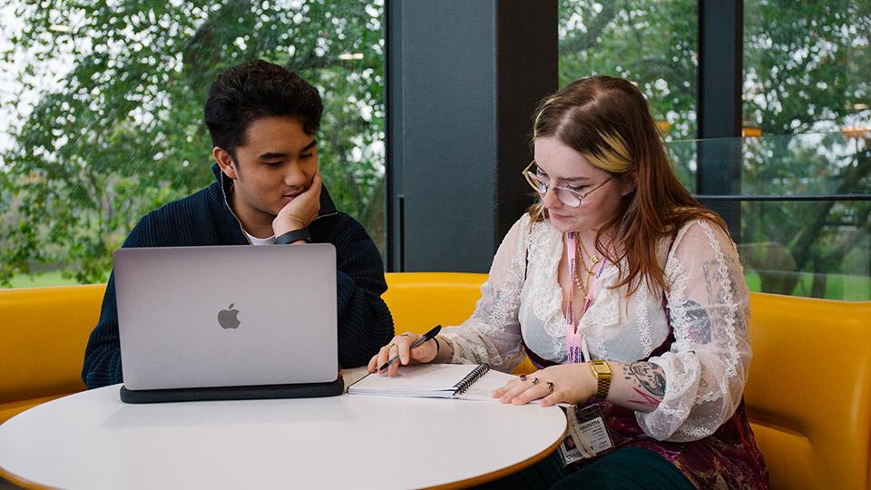 Two students working together at a laptop on the PSH Mezzanine