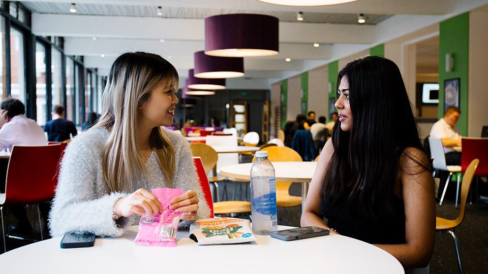 Student sin conversation over lunch in the Refectory