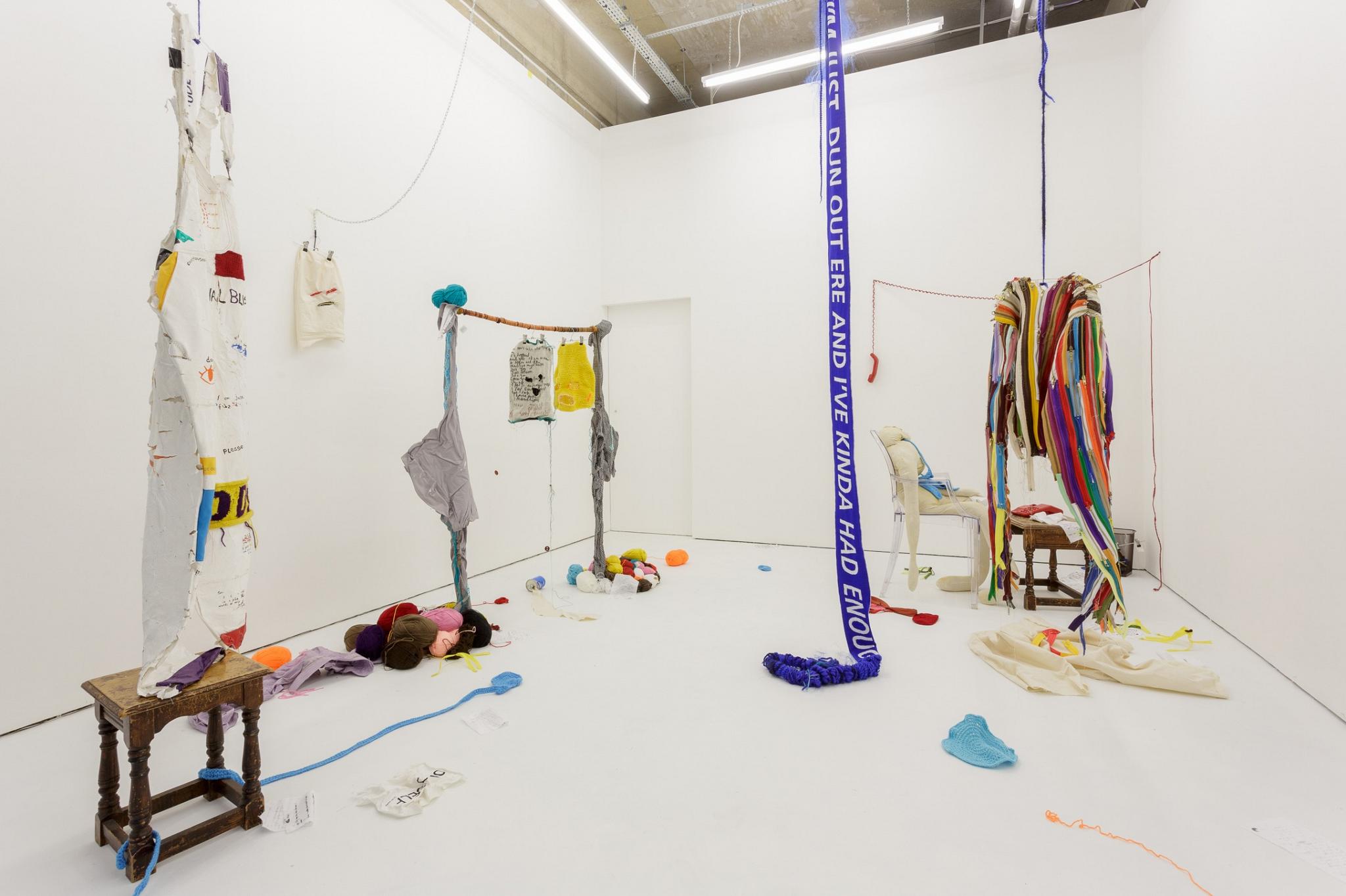Tyreis Holder artwork, a large white room with a cotton apron in the foreground with piles of knitting balls on the floor